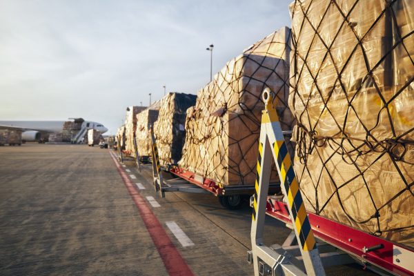 Loading of cargo containers to airplane at airport.